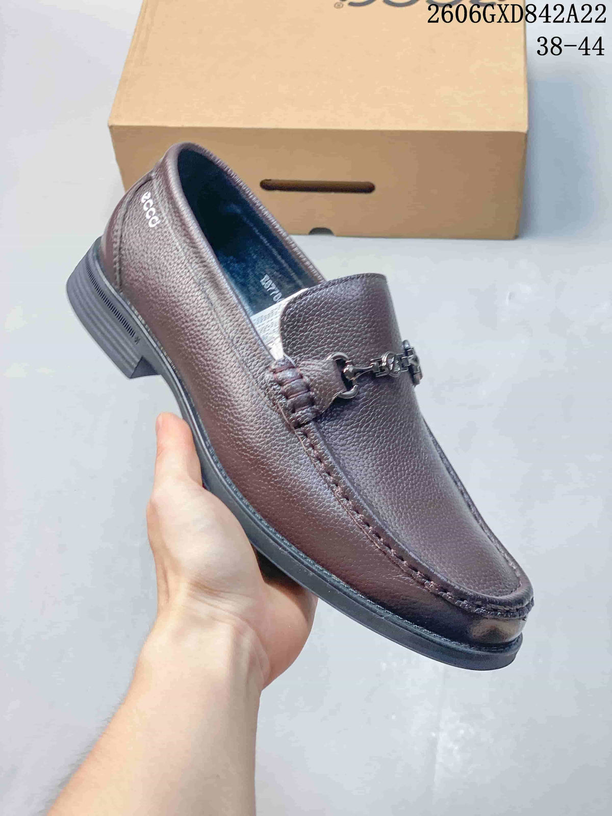 Close-up side view of a brown leather-style loafer with metal bit detail.