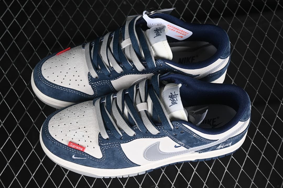 Pair of navy, white, and gray low-top sneakers with two-tone laces