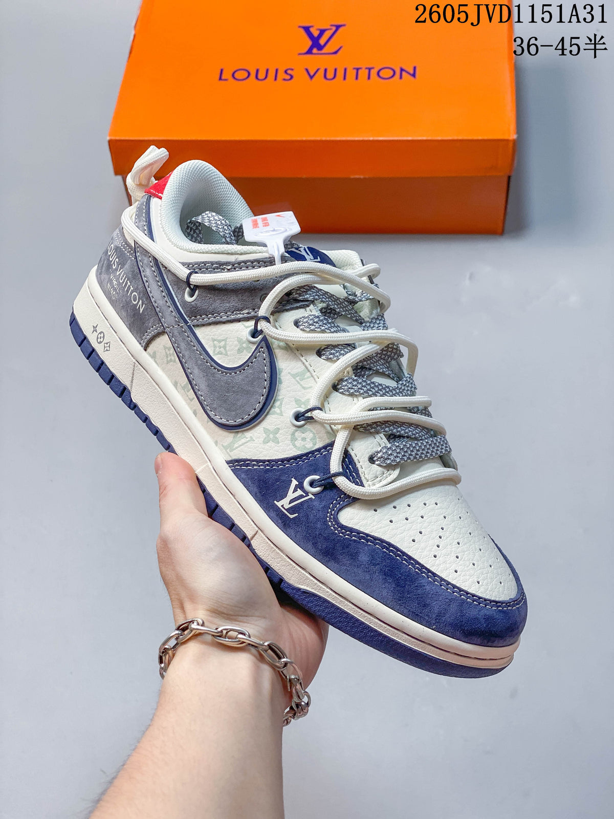 Close view of a cream sneaker with navy and gray overlays, patterned side panels, and layered laces.