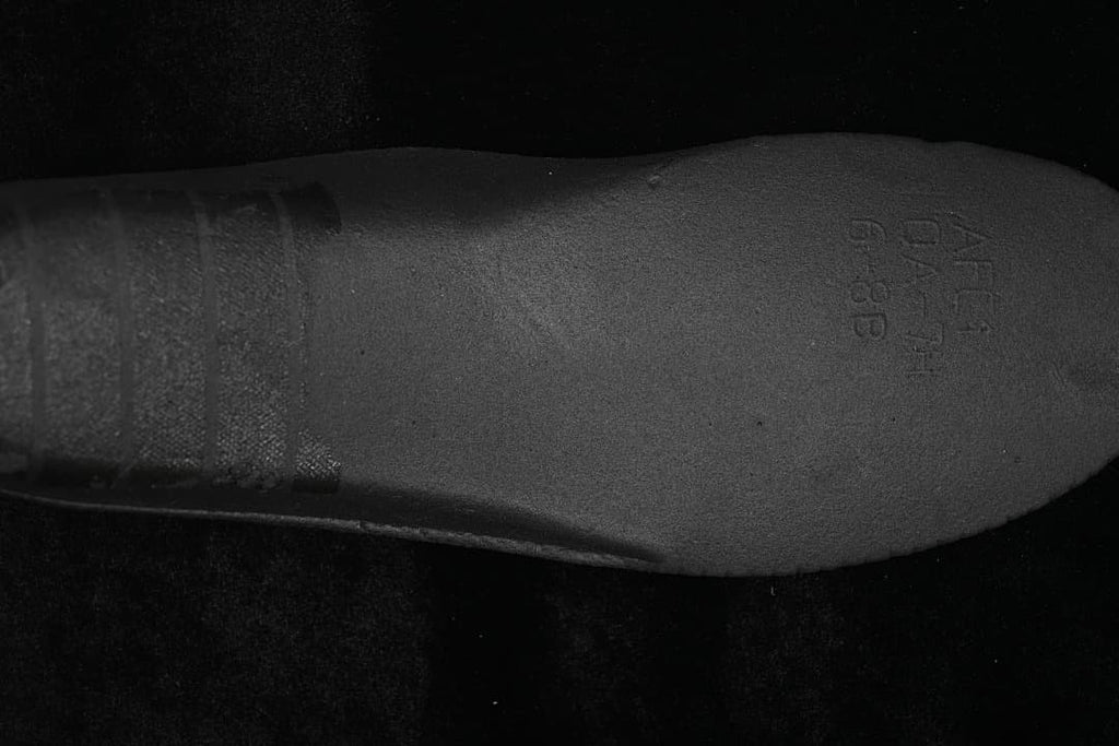 Close-up of a dark insole with faint size or product markings