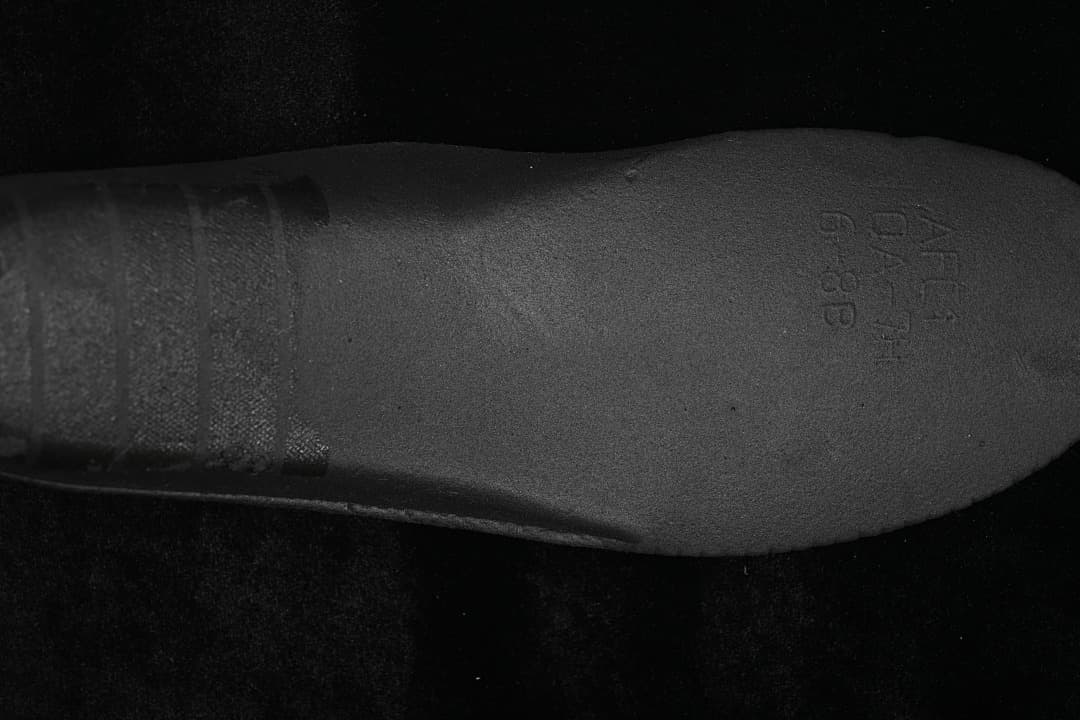 Close-up of a dark insole with faint size or product markings