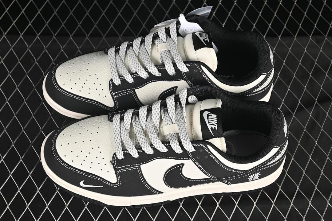 Top view of a pair of black and off-white low-top sneakers with patterned laces and perforated toe panels