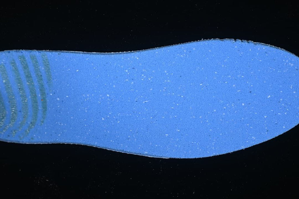 Close-up of a blue shoe insert or insole against a dark background.