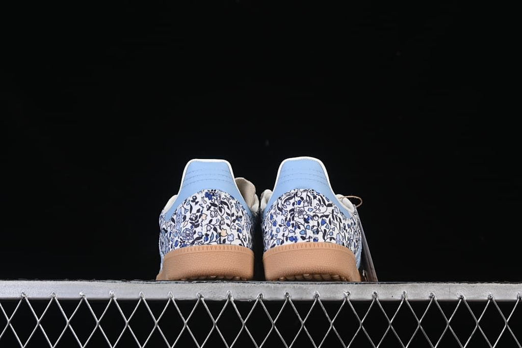 Rear view of both sneakers showing floral-print heels and gum-colored soles
