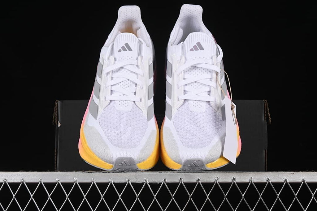 Front view of the pair showing white uppers, grey stripes and yellow toe accents