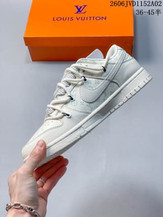 Side profile of the white low-top sneaker showing the layered upper, stitched panels, gray patterned laces, and textured sole.