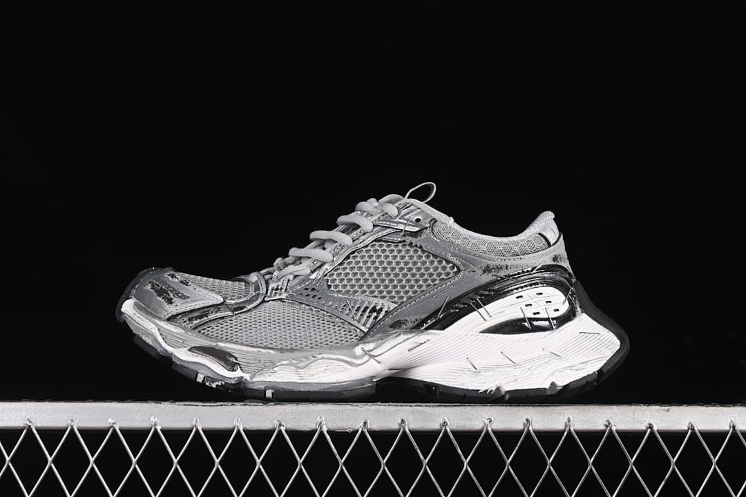 Side view of a grey and silver Balenciaga-style chunky sneaker against a black background