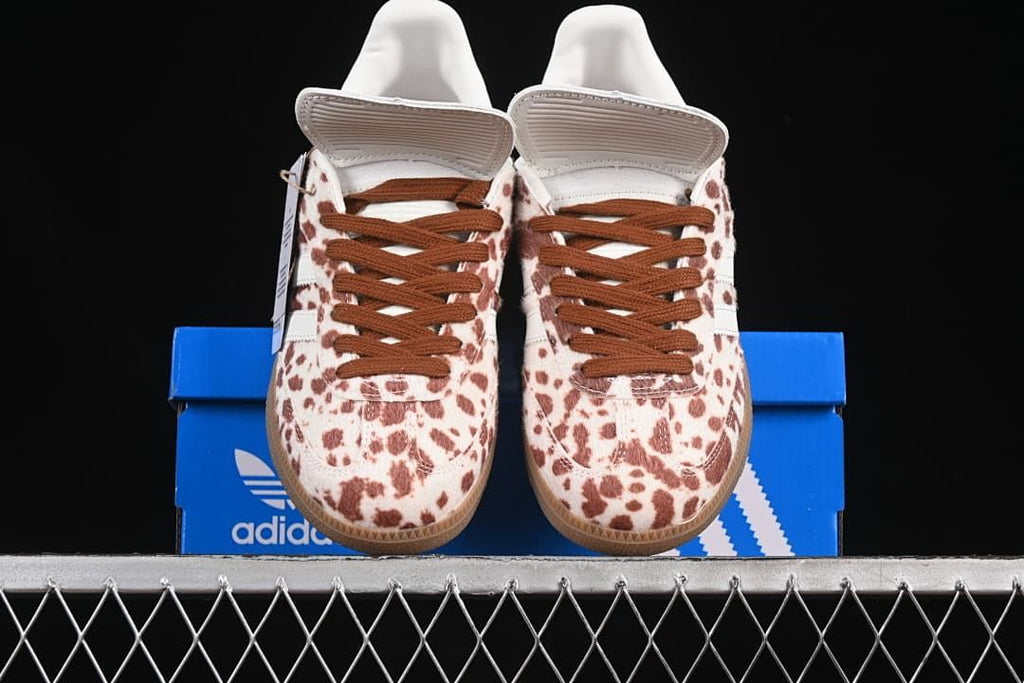 Front view of a pair of spotted sneakers displayed on a blue box