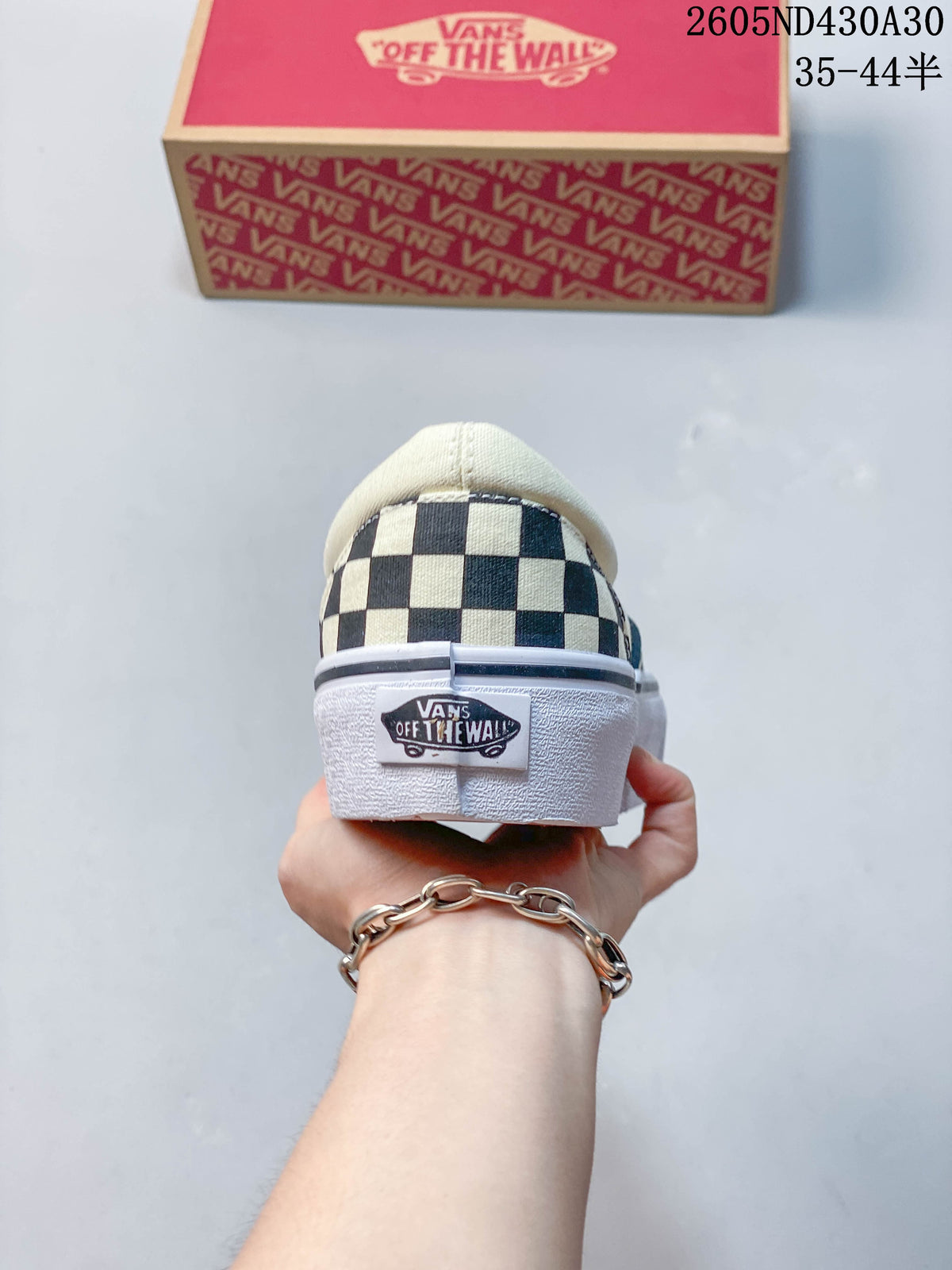 Rear view of checkerboard slip-on sneakers showing the heel and raised white sole.