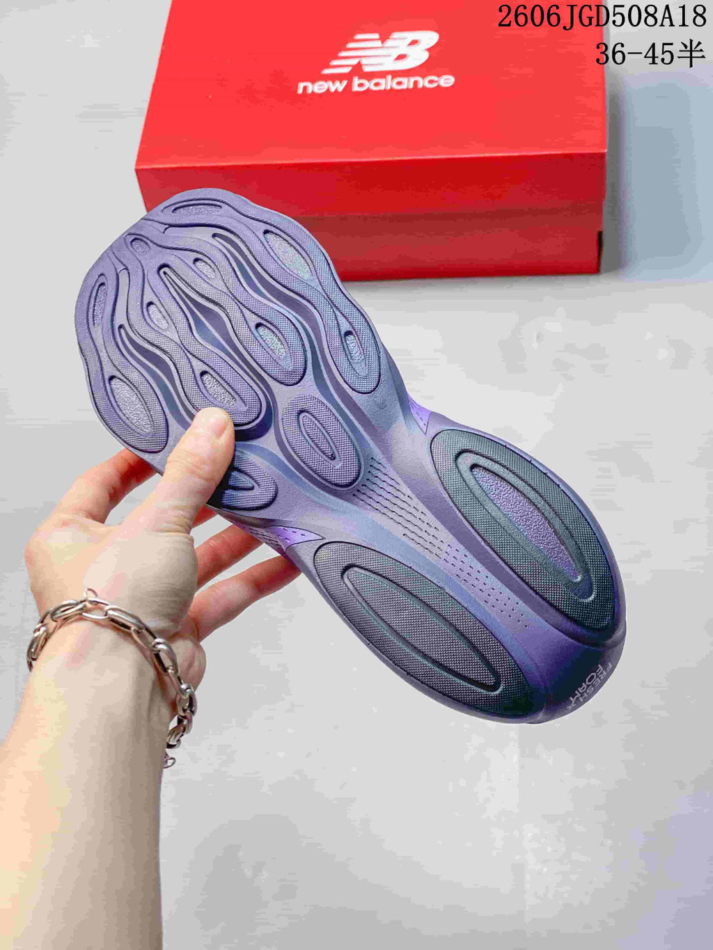 Underside view of the purple shoe showing the sculpted outsole