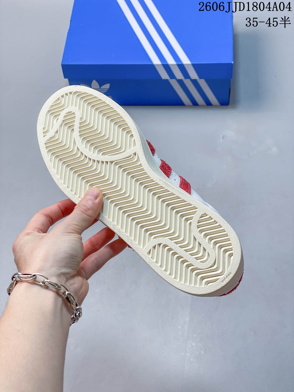 Underside view of the sneaker showing its patterned off-white outsole.