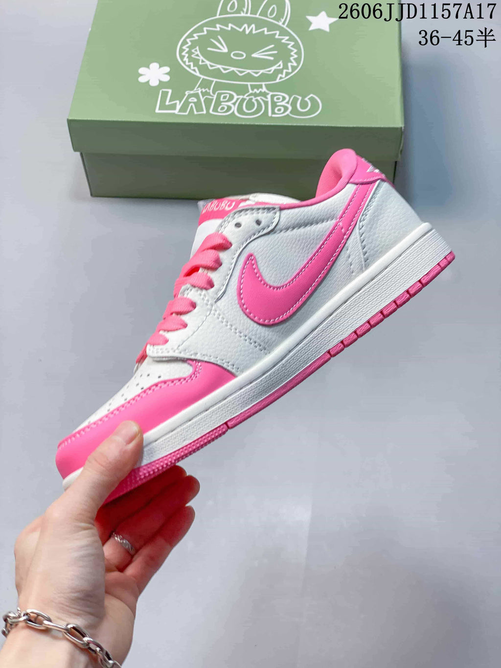 Side view of the white and pink low-top sneaker with a pink Swoosh-shaped panel