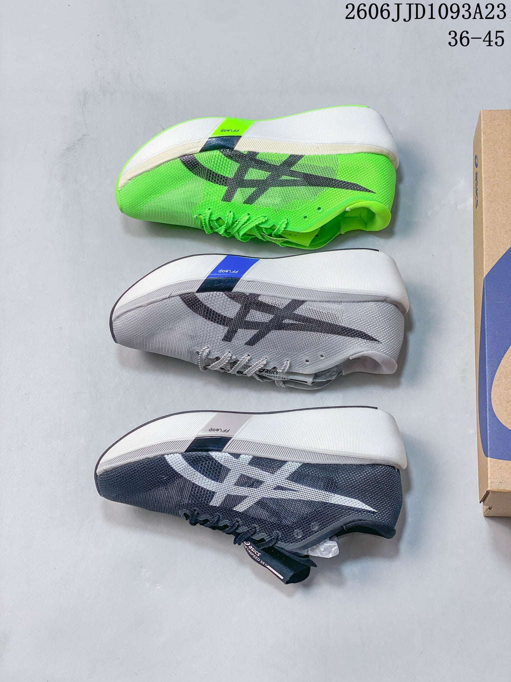 Three ASICS running shoes in bright green, light gray, and dark navy, shown from the side