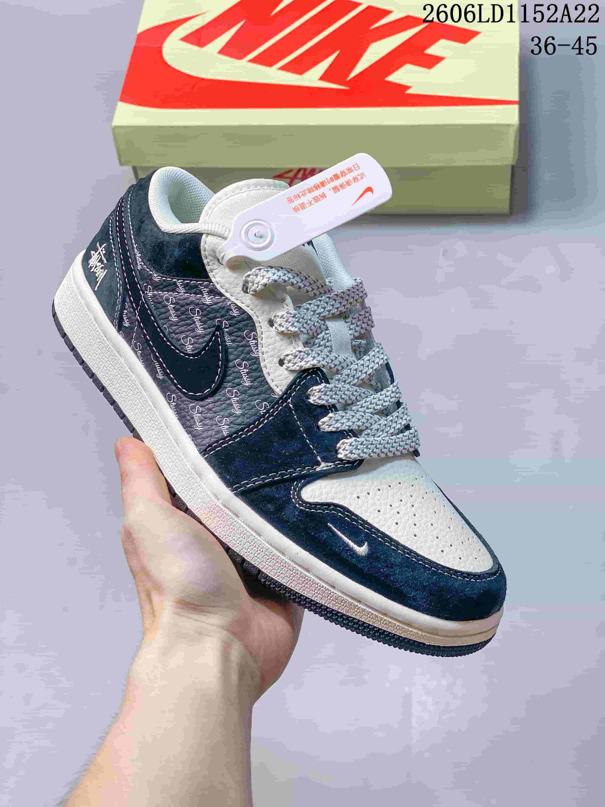 Low-top sneaker with white and navy panels, repeating script-style graphics, and patterned laces; size range 36–45 is printed in the image.