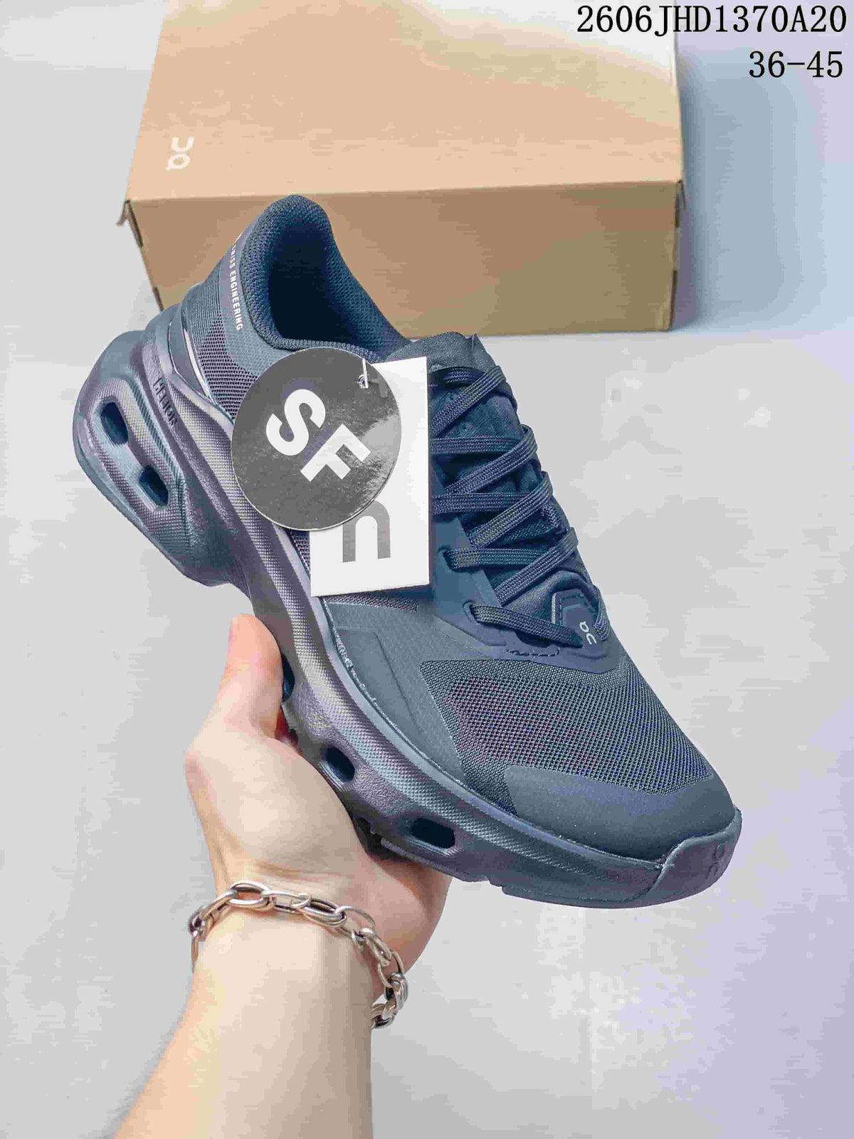 Angled view of a charcoal gray sneaker with a sculpted sole and mesh-like panels.
