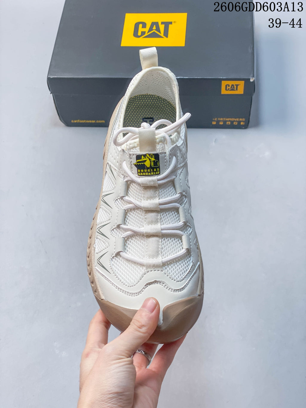 Front view of a white CAT sneaker with lace-up closure and mesh panels