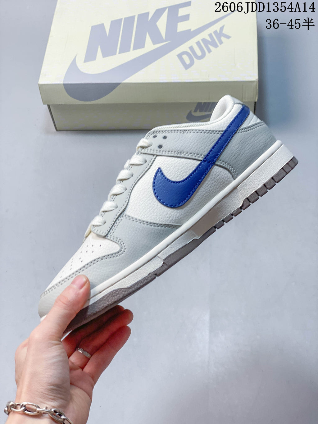 Side profile of a white and grey low-top sneaker with a blue Swoosh