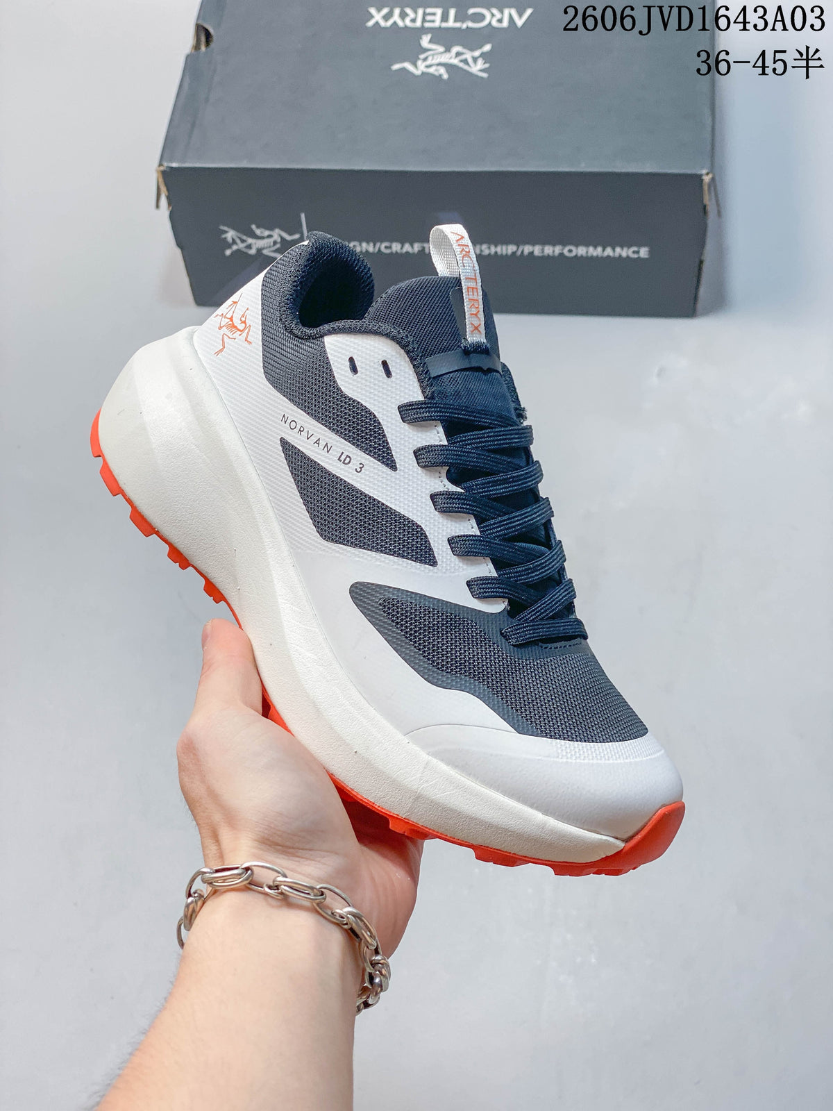 Navy and white Norvan LD 3 shoe with orange outsole accents