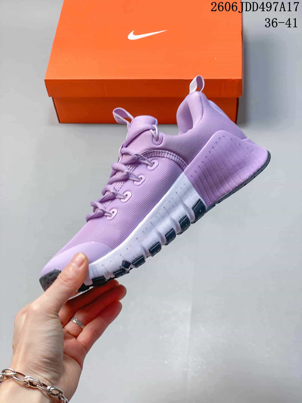 Side view of a lavender training shoe with a segmented white midsole