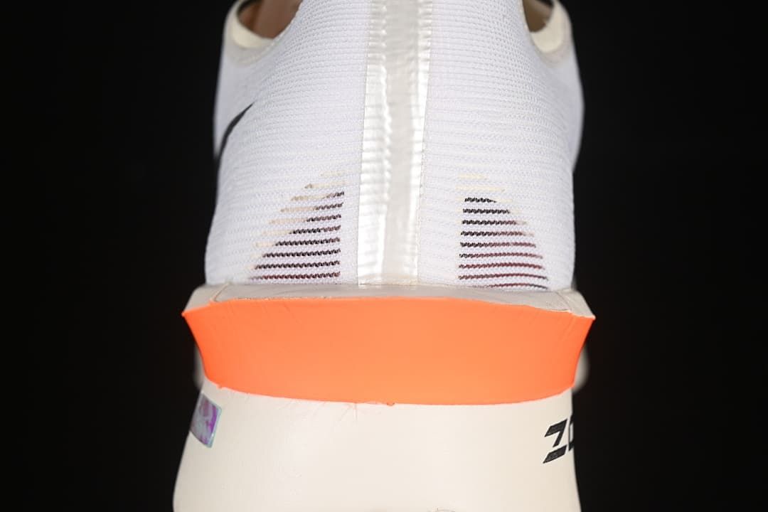 Rear view of the white shoe with orange heel detail