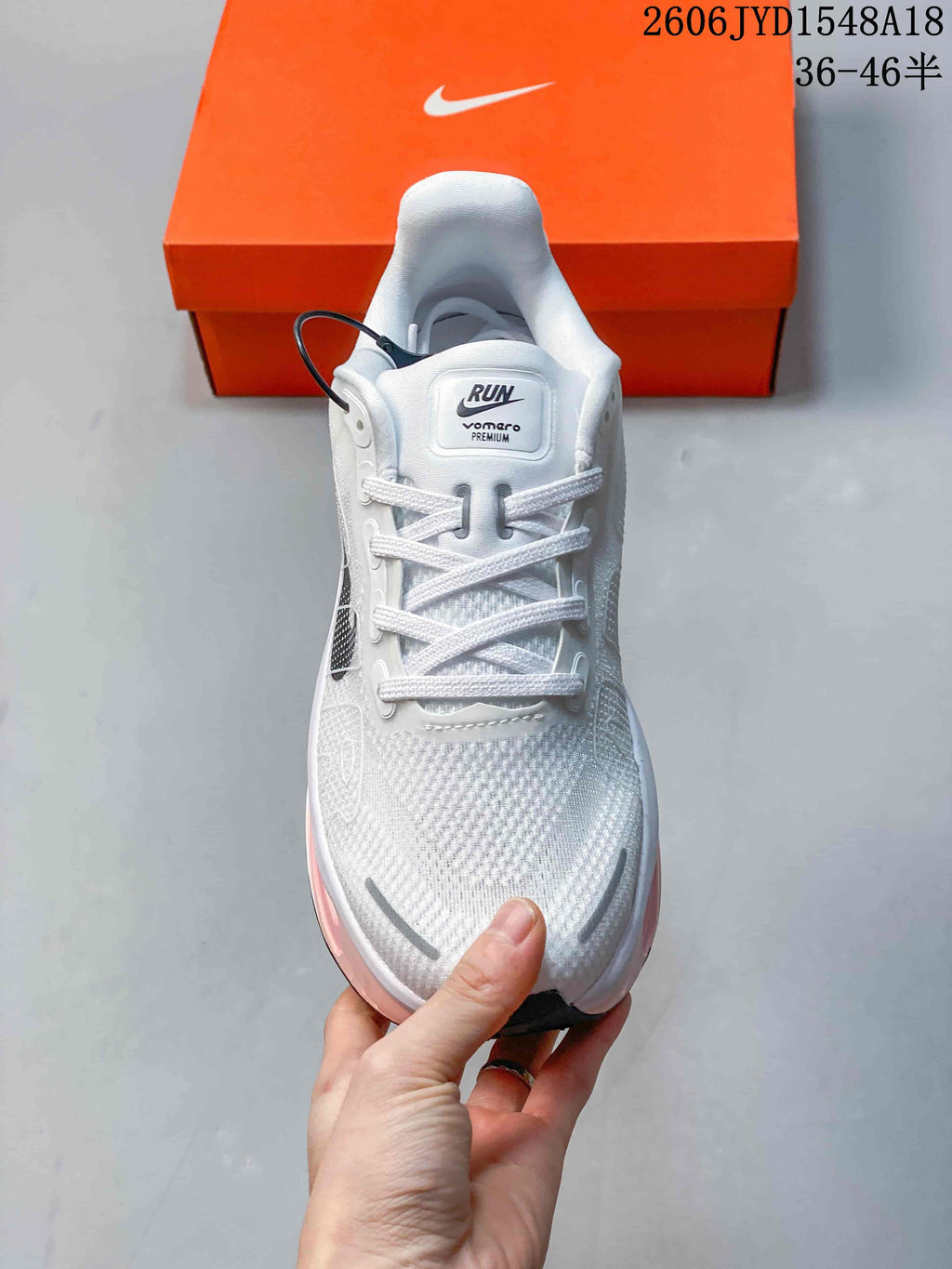 Front view of the white lace-up running shoe with dark detailing.