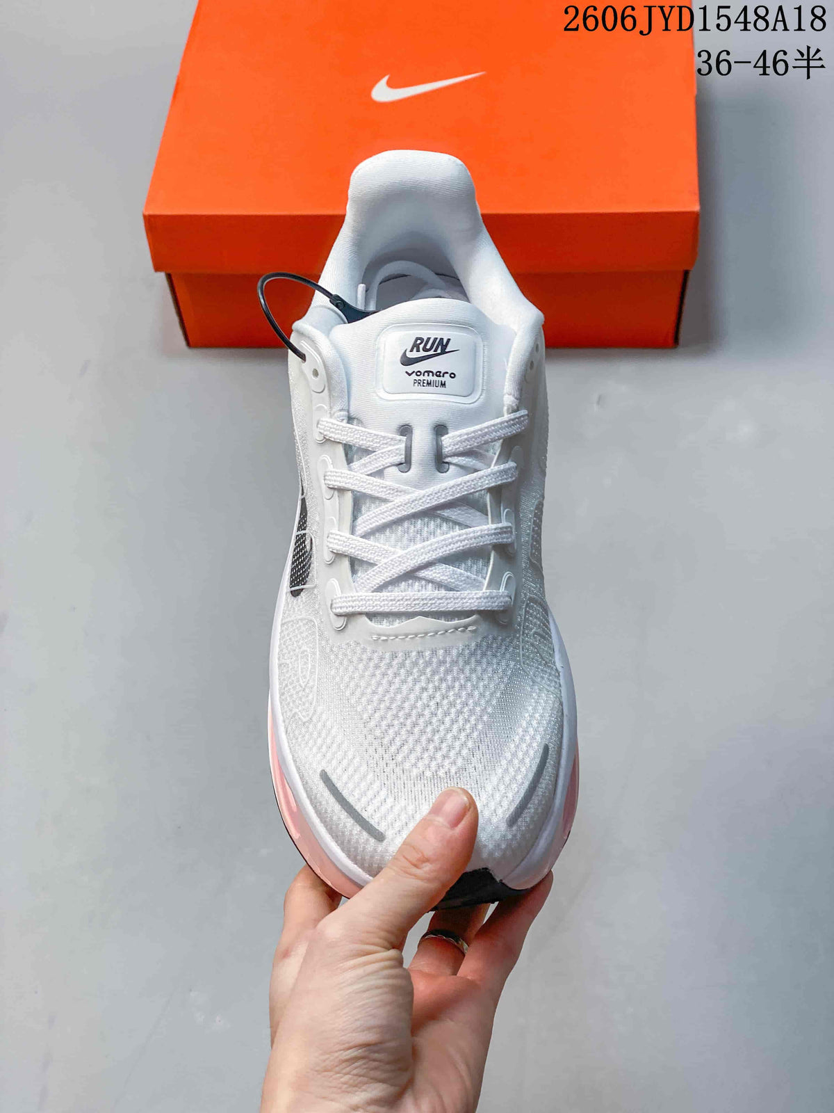 Front view of the white lace-up running shoe with dark detailing.