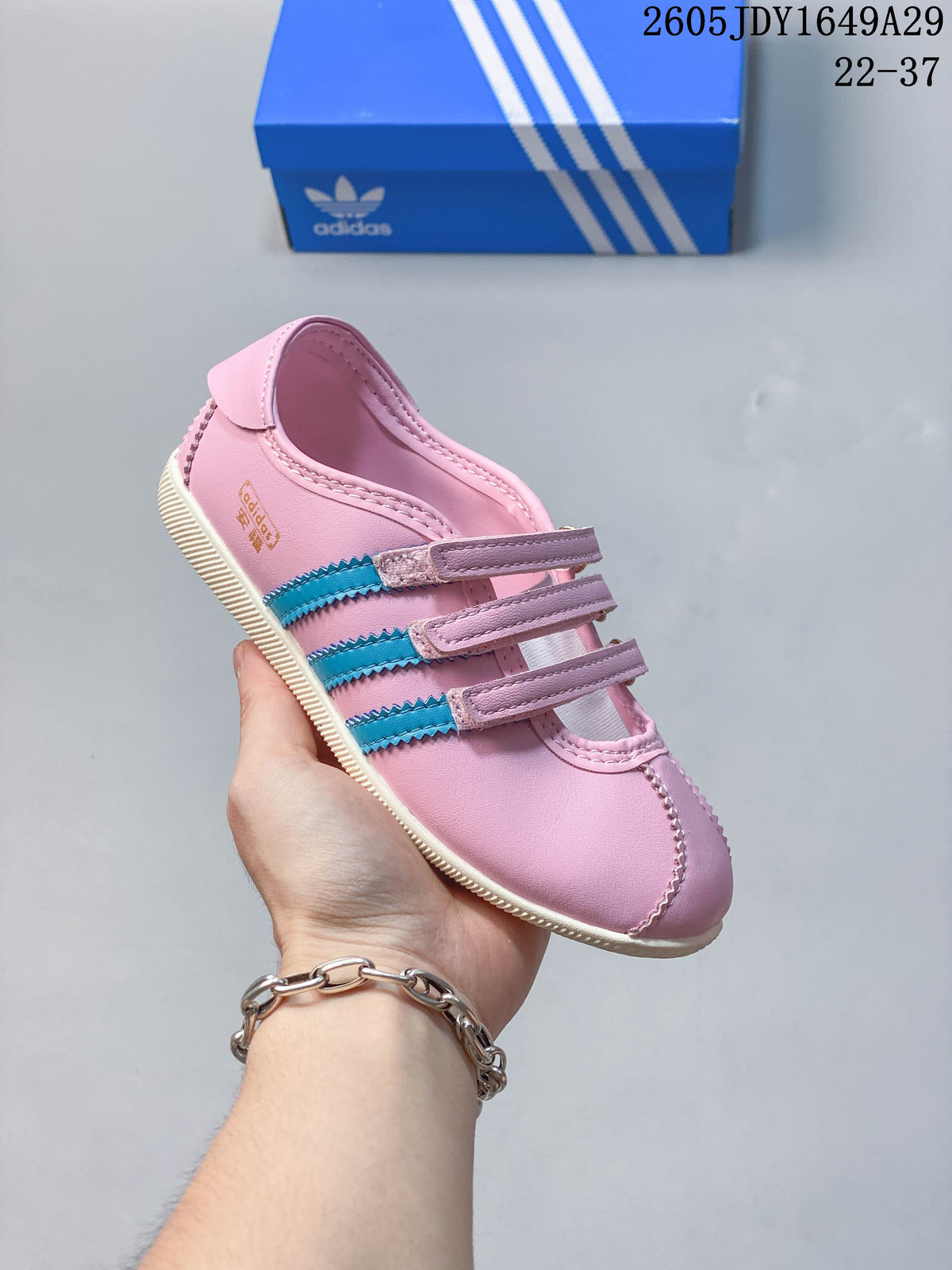 Side view of the pink sneakers with blue stripes and a cream-colored outsole.