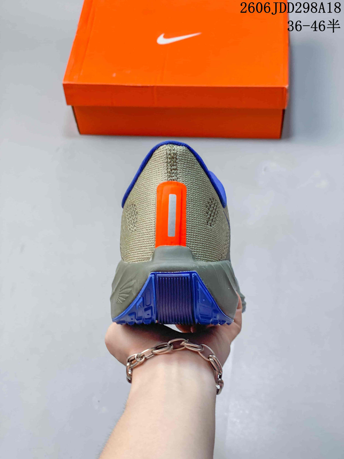 Rear view of a running shoe showing the blue heel outsole and orange heel detail