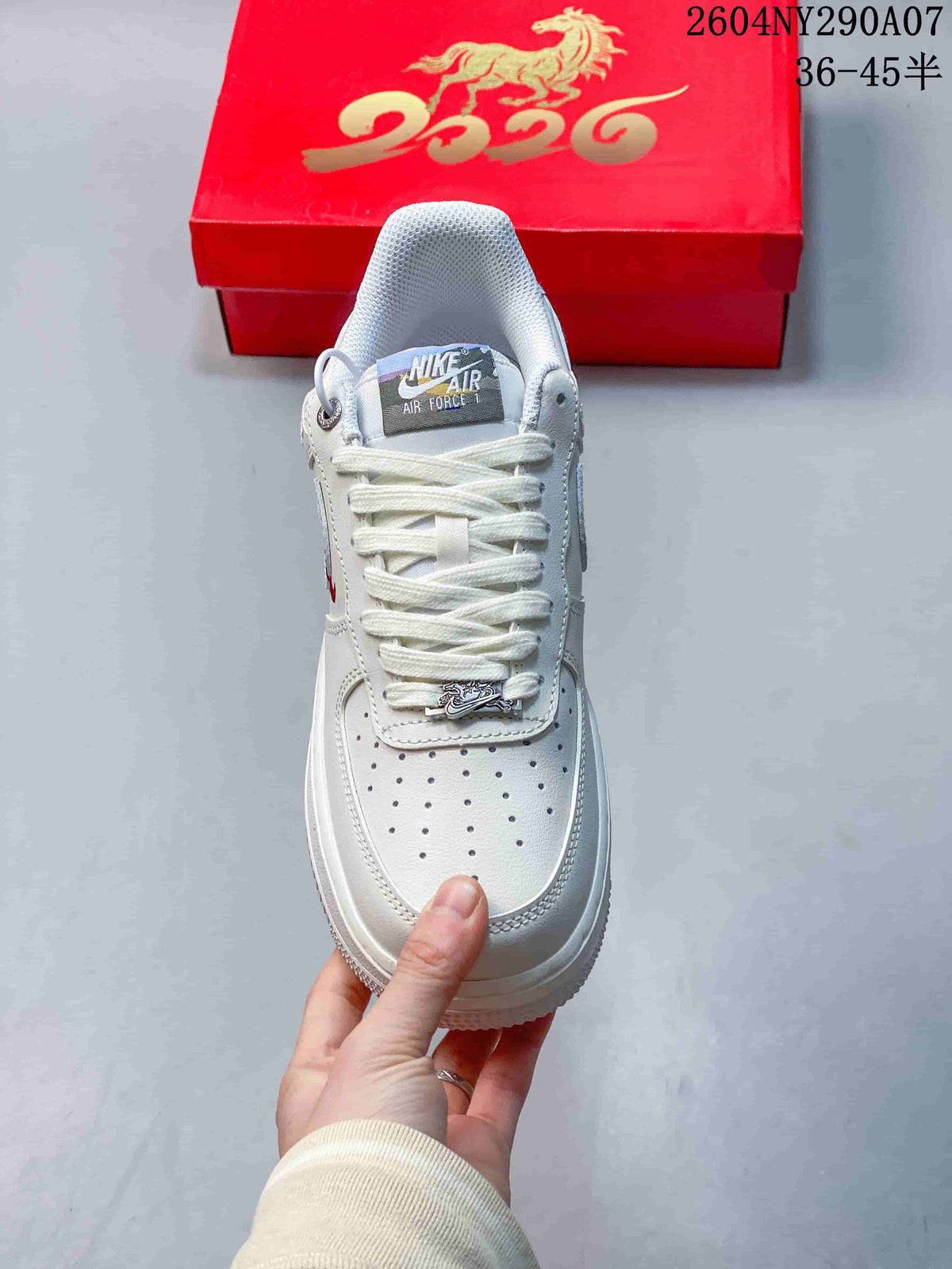 Front view of a white lace-up sneaker with perforated toe and decorative lace hardware