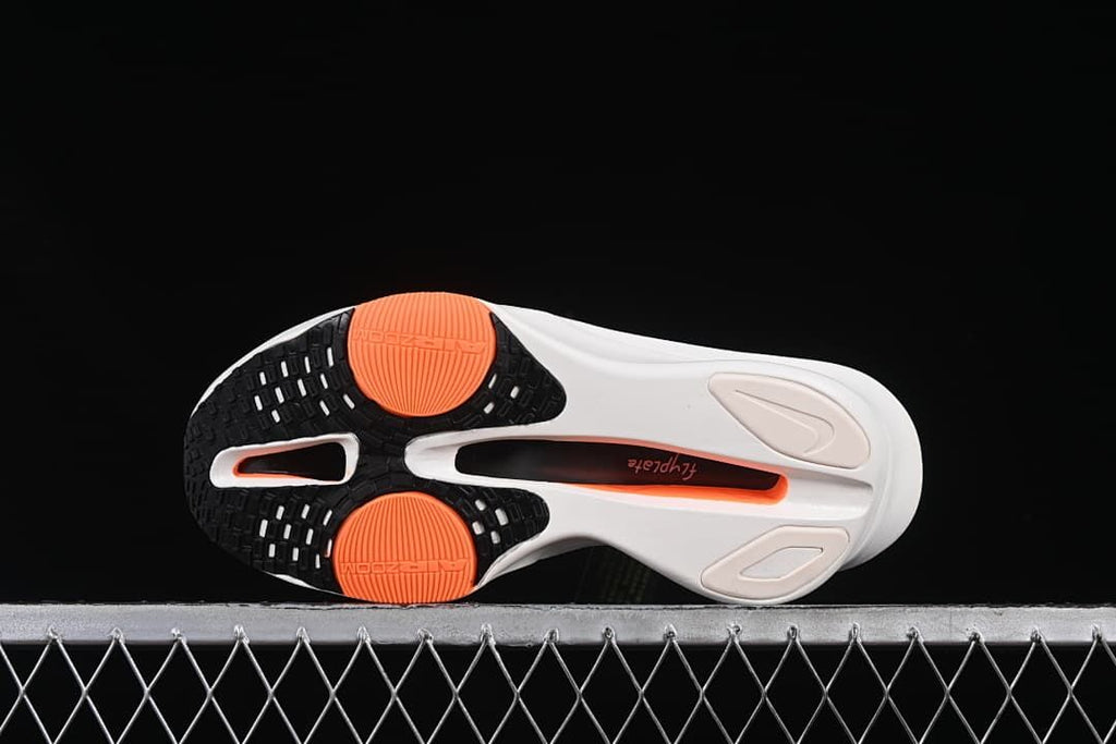 Underside of the shoe showing black and orange outsole sections