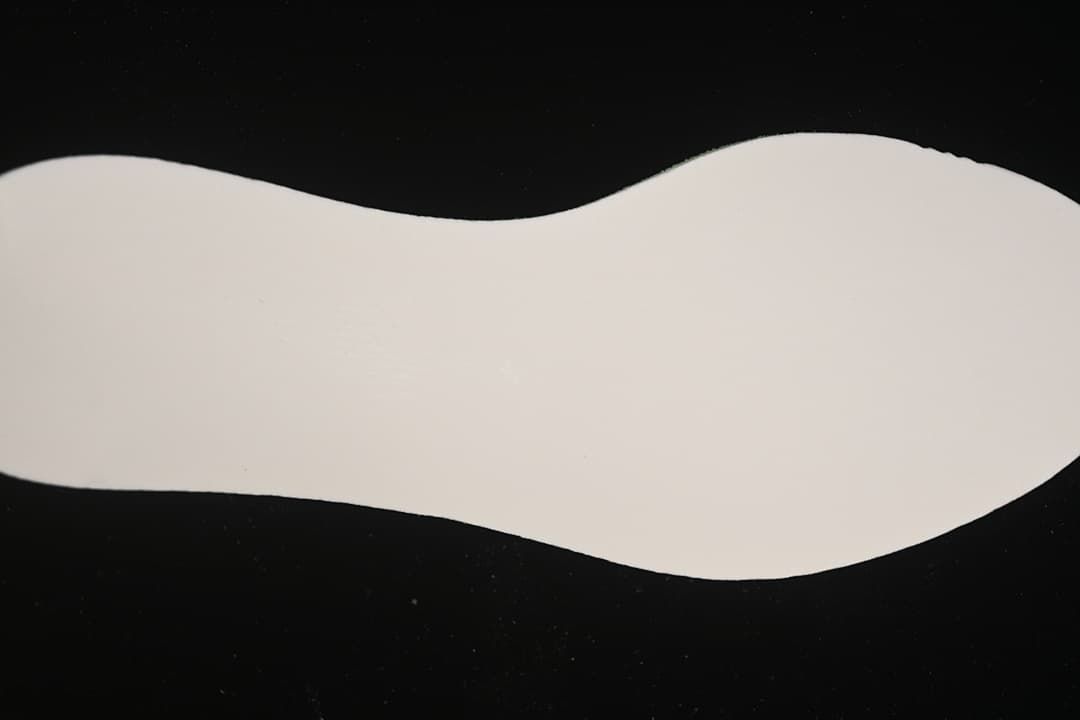 Plain white shoe-shaped insert displayed on a dark background.