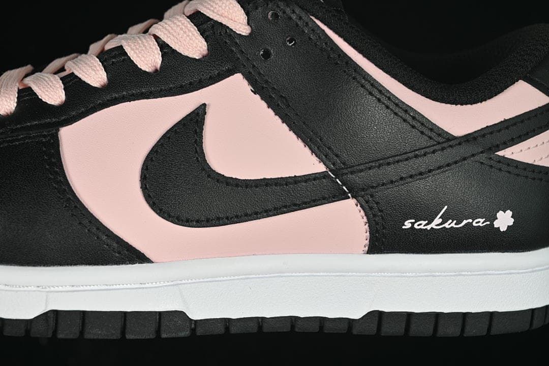 Close-up of black and pale pink side panels, swoosh, and sakura-style embroidery