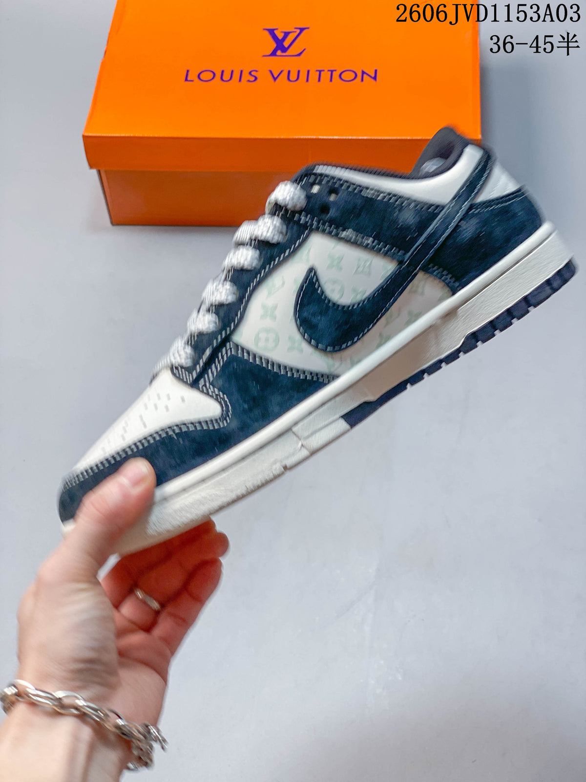 Side view of a low-top sneaker with navy overlays and patterned off-white panels