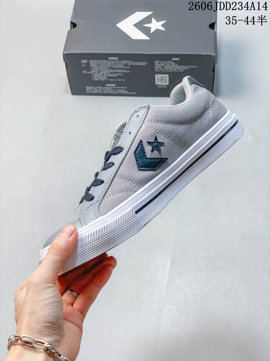Side view of the gray low-top sneaker with star-chevron detailing