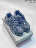 Pair of charcoal gray New Balance 997 sneakers on a shoe box, with code 2605JVD401A31 and size range text visible.