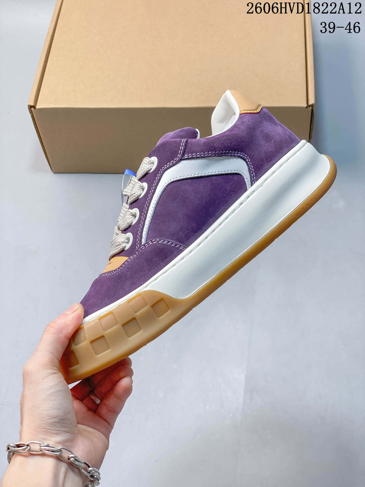 Side view of a purple low-top sneaker with white paneling and a gum-colored sole.