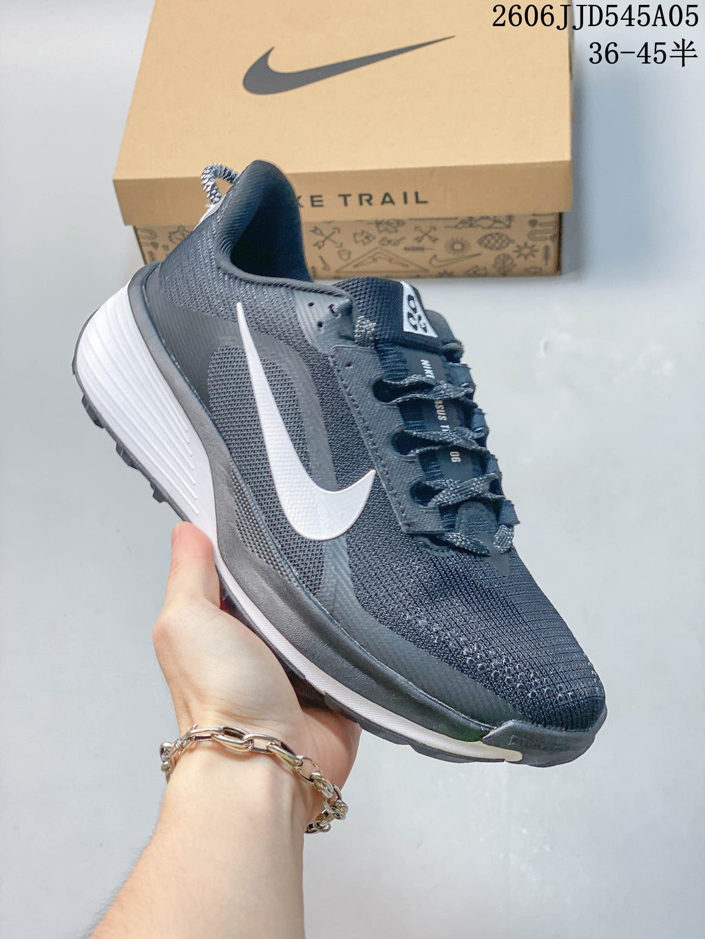 Side view of a charcoal Nike Pegasus Trail 6 shoe with a white swoosh