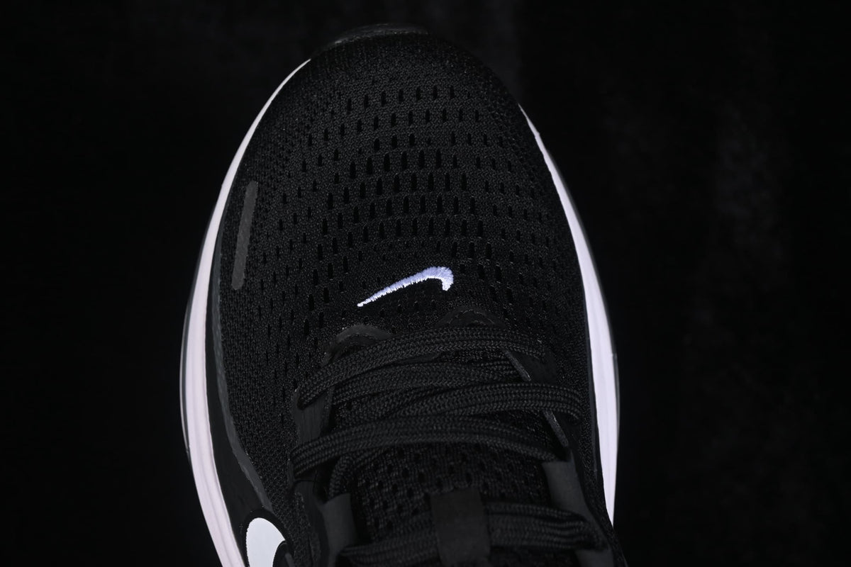 Top-down close-up of the black mesh-textured toe box, laces and small white swoosh.