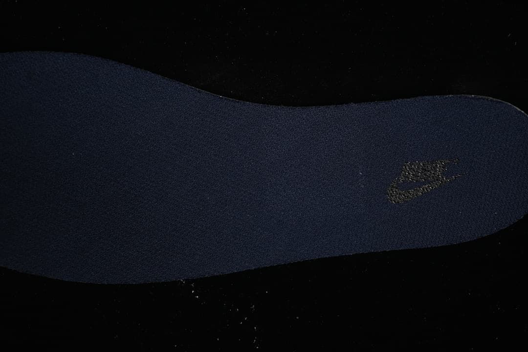 Close-up view of a navy shoe insert with a logo
