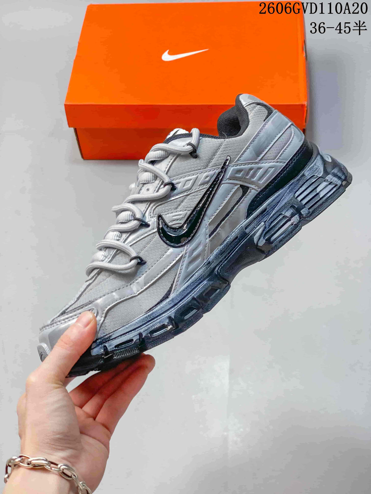 Side view of the layered silver and gray sneaker with dark side detailing.