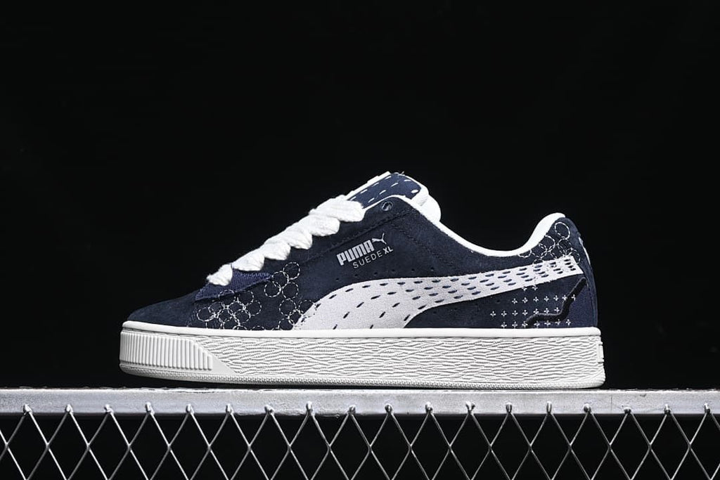 Side view of navy and white Puma Suede XL low-top sneakers