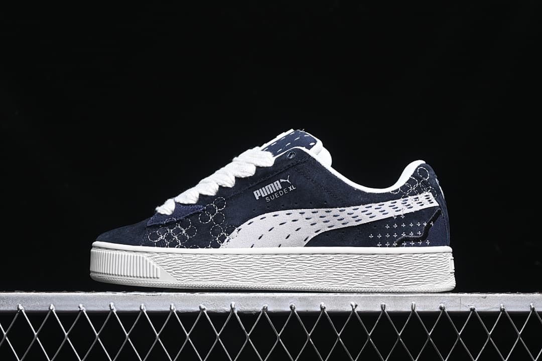 Side view of navy and white Puma Suede XL low-top sneakers