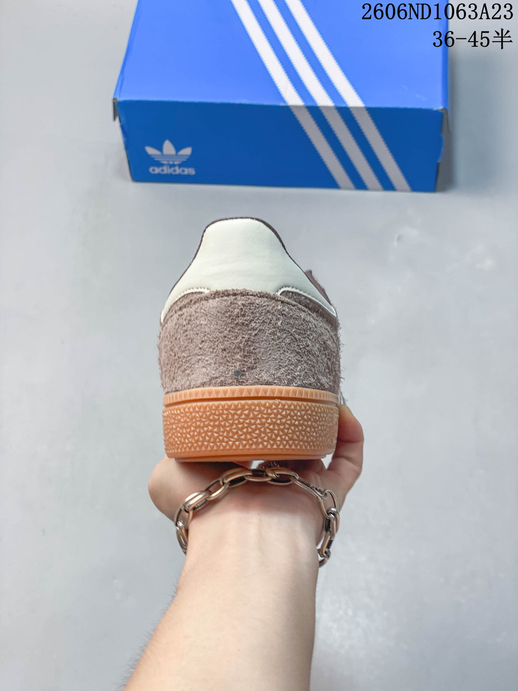 Rear view of the taupe sneaker showing the off-white heel detail and gum-colored sole.