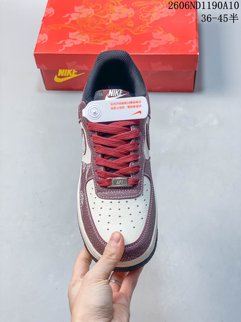 Top view showing perforated off-white toe, burgundy overlays, and red laces