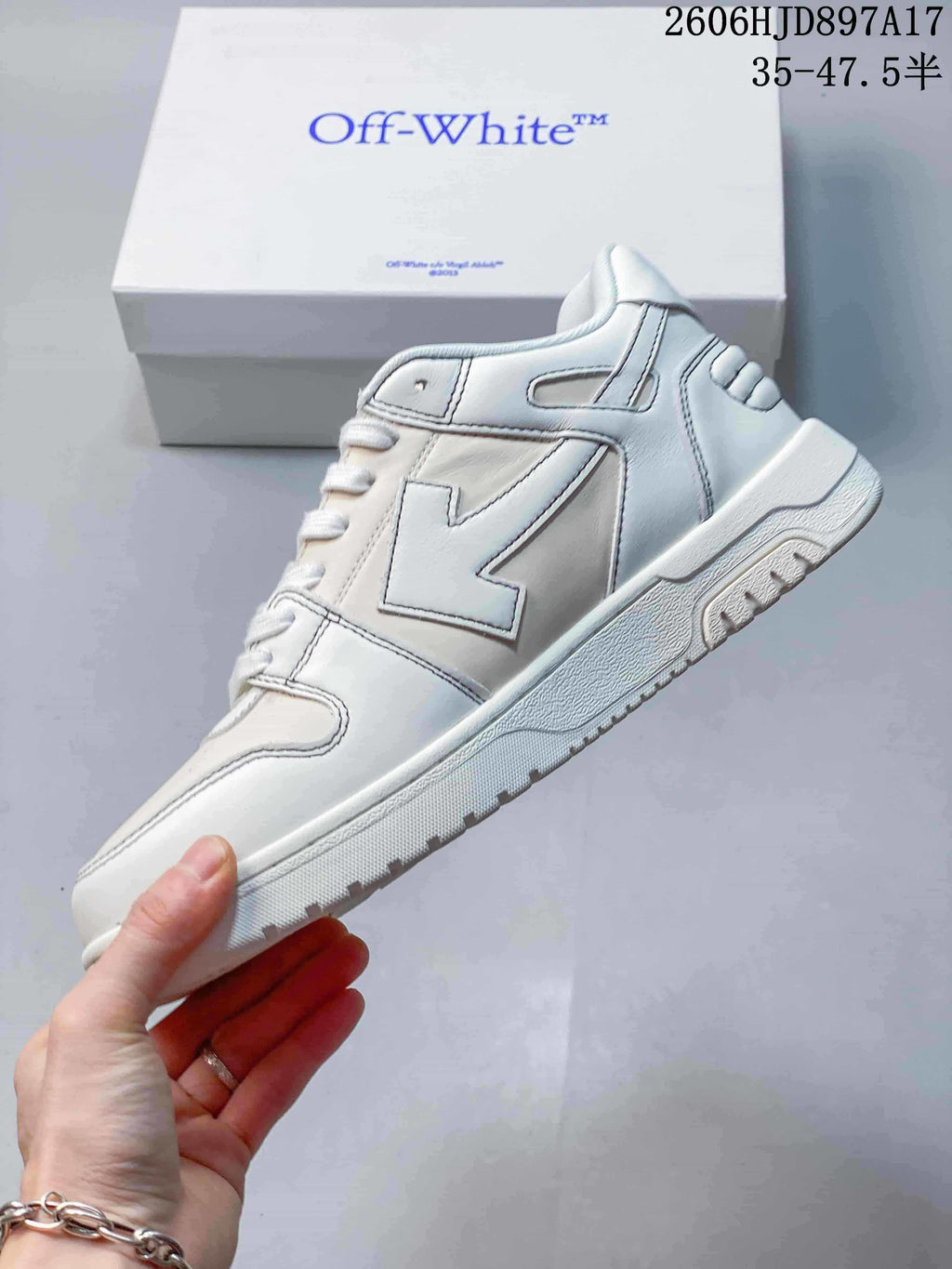 Side view of a white sneaker with paneled construction and an arrow-shaped detail