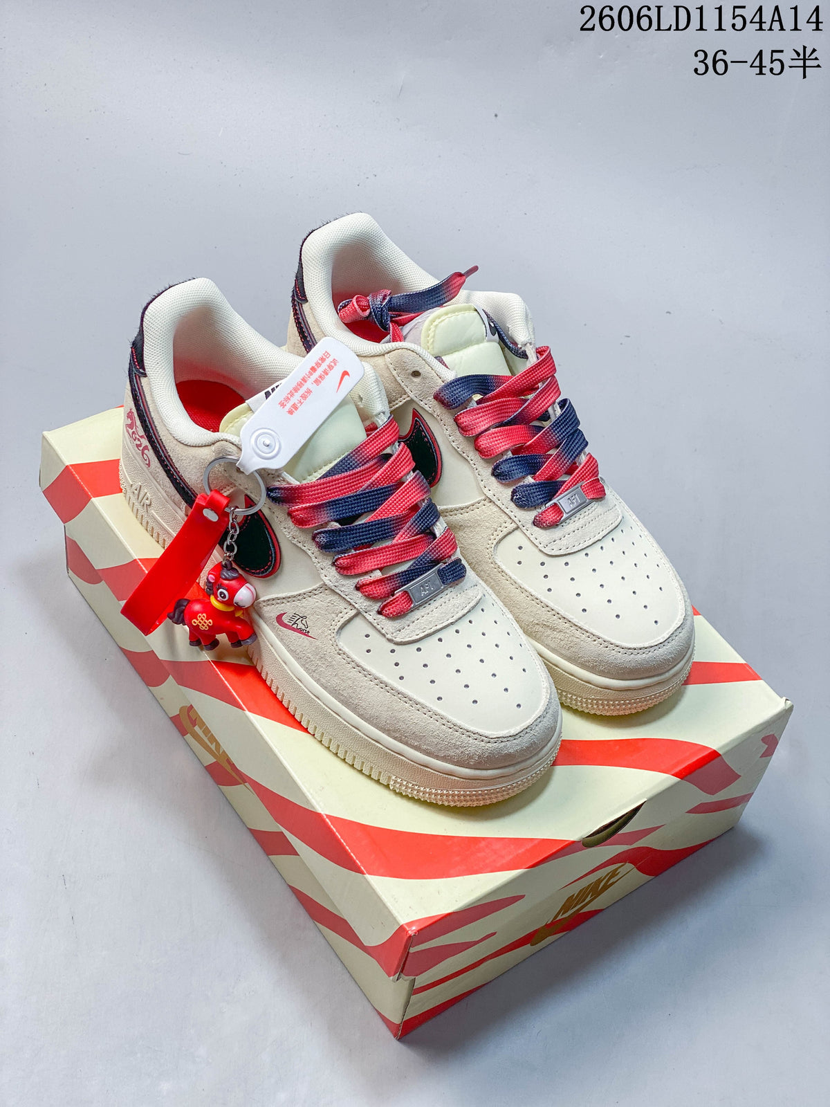 Pair of cream Nike Air Force 1 '07 low-top sneakers with red and navy accents and a character keychain