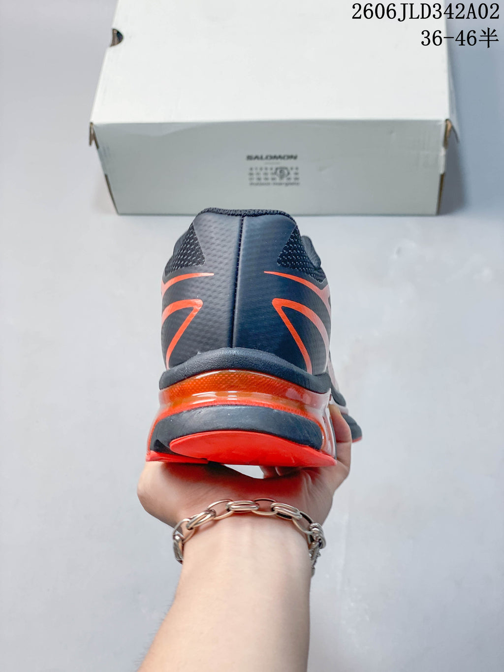 Rear view of the navy and orange trail running shoe.