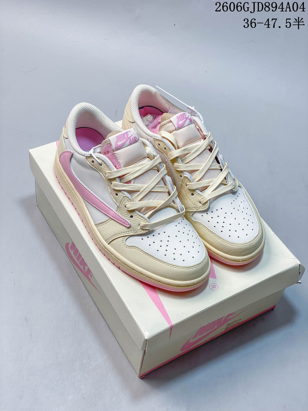 Pair of cream, white, and pink low-top sneakers with perforated toe boxes