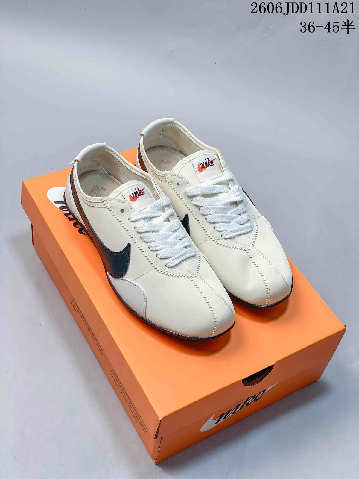 Pair of off-white Nike Moon Shoe OG Summit low-top sneakers with dark Swooshes and white laces, shown on an orange shoe box