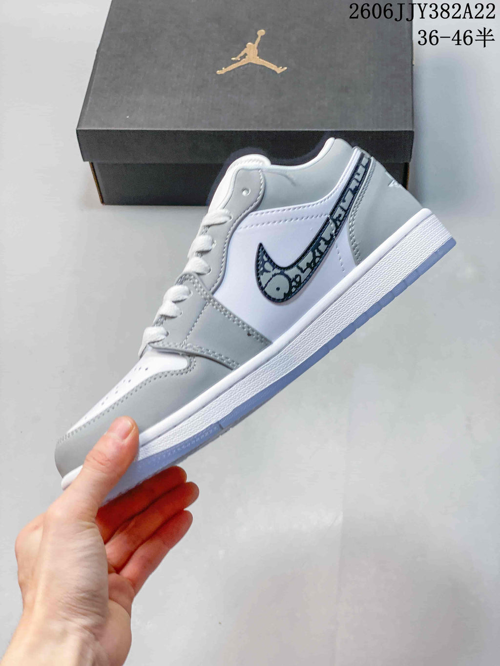 Side view of a white and grey low-top sneaker with a patterned Swoosh
